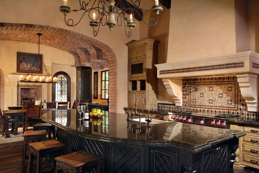 Mediterranean style kitchen with exposed brick archway and rustic dining island