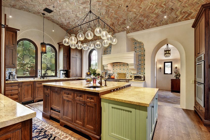 Kitchen with chevron pattern bricks on the ceiling, blown glass chandelier and arched window