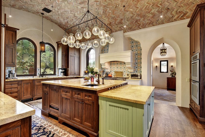 Kitchen with chevron pattern bricks on the ceiling, blown glass chandelier and arched window 