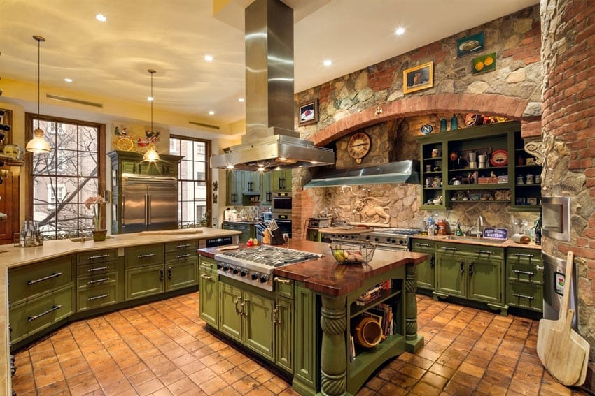 Rustic kitchen with dark green cabinets and brick wall with terra cotta tile floors
