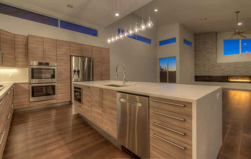 Modern open concept kitchen with rectangular island, wood flooring and pendant lights