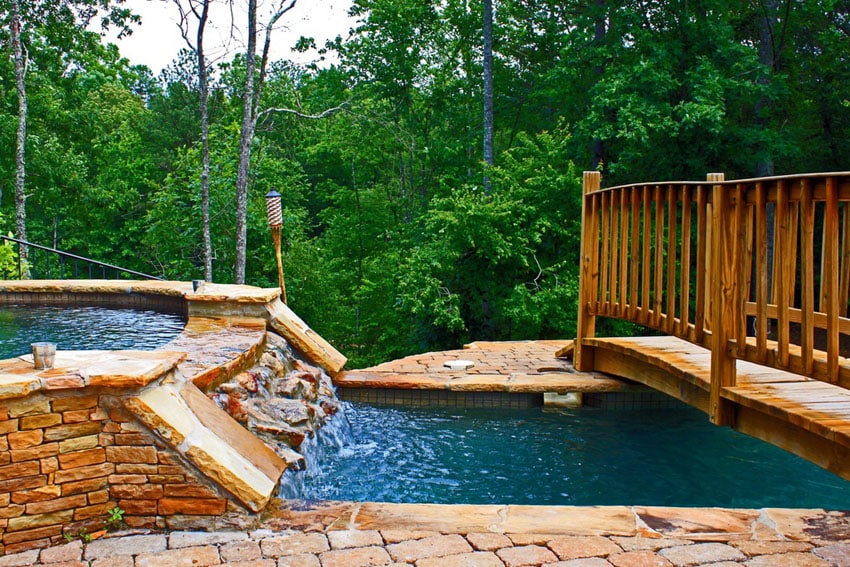 Natural looking rock waterfall attached to swimming pool