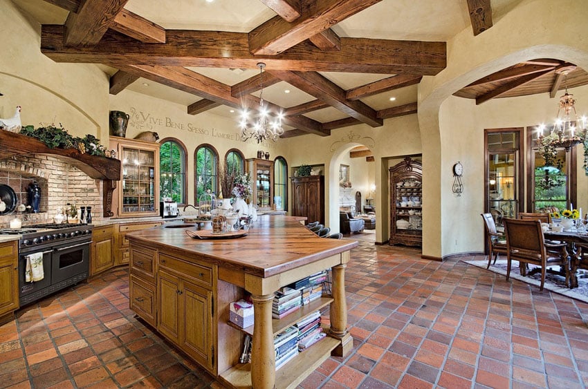 Open concept kitchen with high ceilings arched doorways and Spanish tile flooring