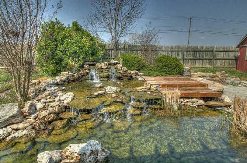Rock waterfall and pond next to wood deck