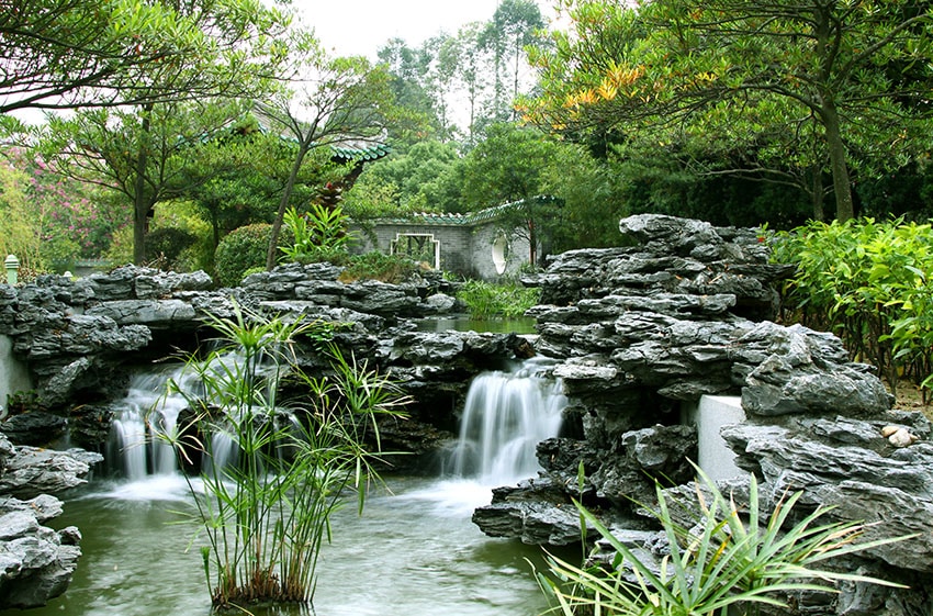 Chinese garden with flowing waterfalls pver natural looking stone formations
