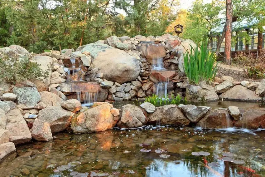 Rustic rock waterfall in backyard
