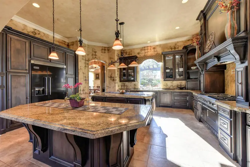 Kitchen with light brown granite slab counter and cabinets with dark finish