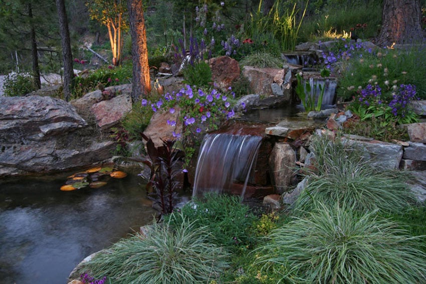 Small creek water feature with waterfalls in to pond