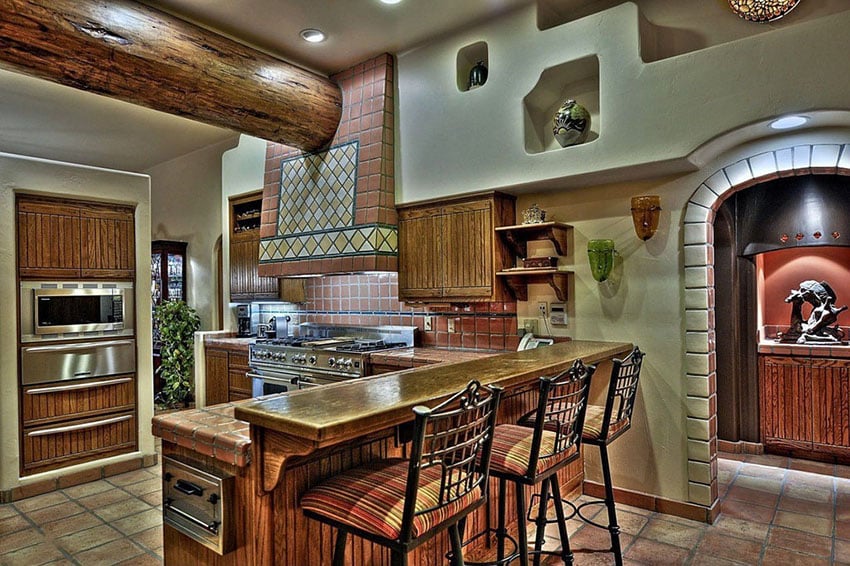 Spanish style kitchen with tile backsplash and floors with breakfast bar
