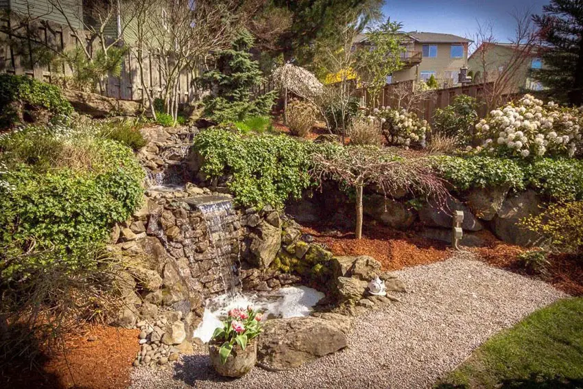 Stacked stone waterfall in backyard