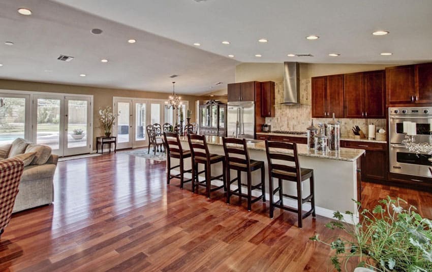 Traditional kitchen with open layout with hardwood floors and long rectangular dining island