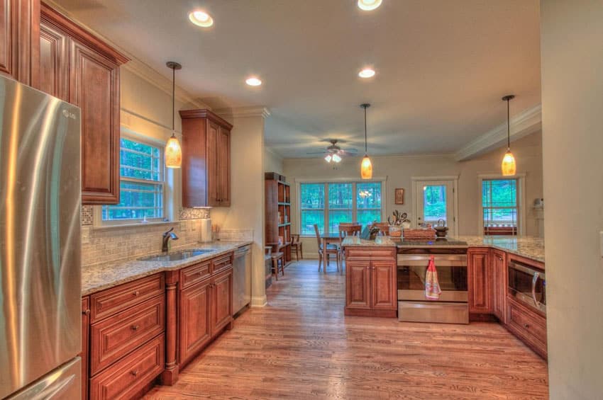 Kitchen with red oak flooring, hanging lights and cabinets made of wood