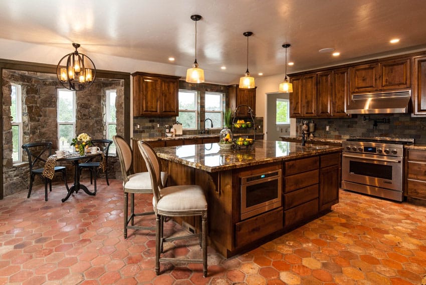 Traditional kitchen with terra cotta tile floors stone walls