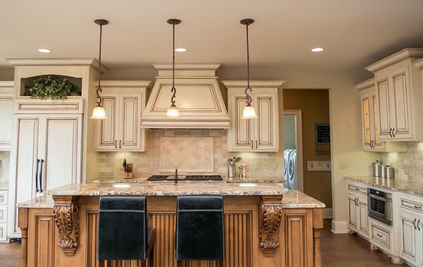 Kitchen with ornate island with marble countertop and decorative pendant lights