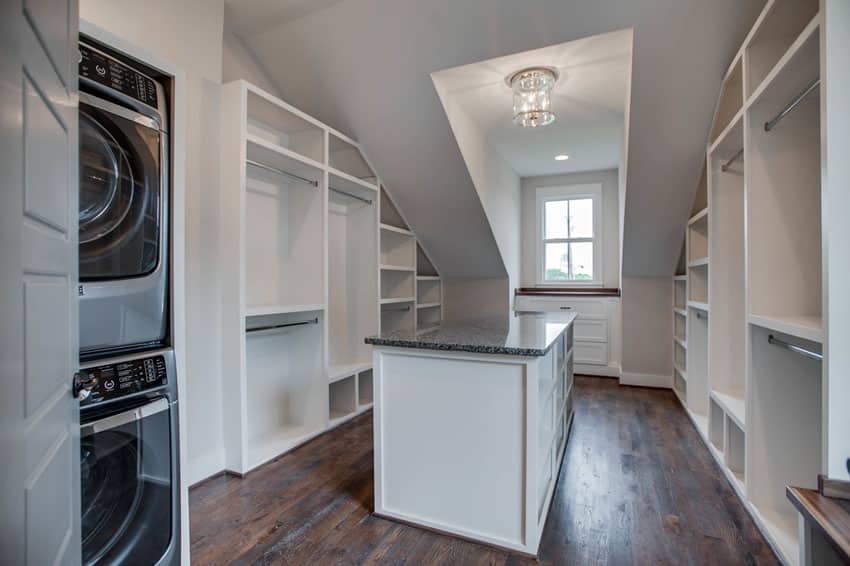 Closet with hardwood floors and washer and dryer and white cabinets