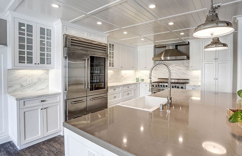 White cabinet kitchen with quartz island and marble counters backsplash