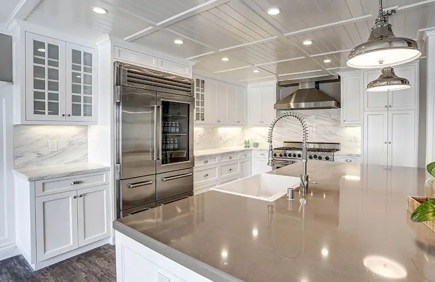 White cabinet kitchen with quartz island and marble counters and backsplash