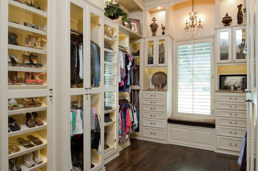 White walk in closet with hardwood floors shoe rack mirror dresser drawers and window view