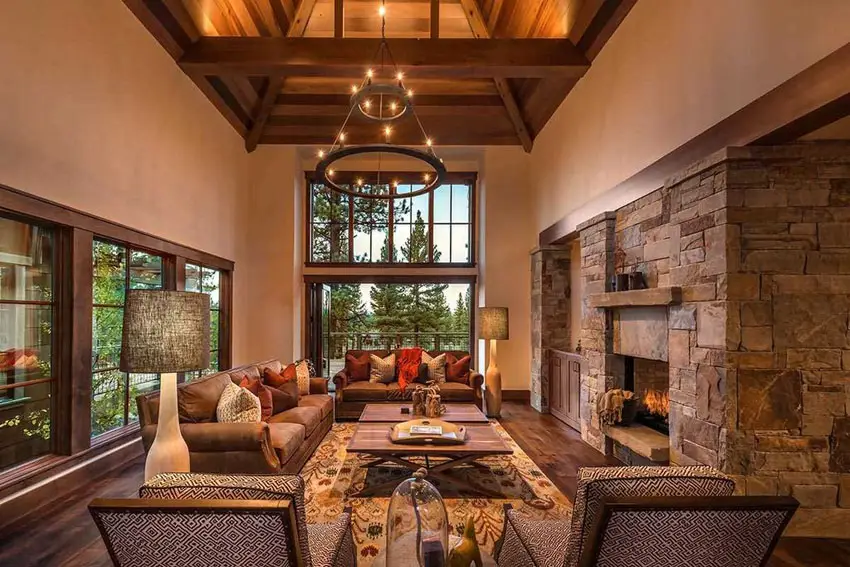 Alpine room with large stone fireplace, wood flooring and French windows