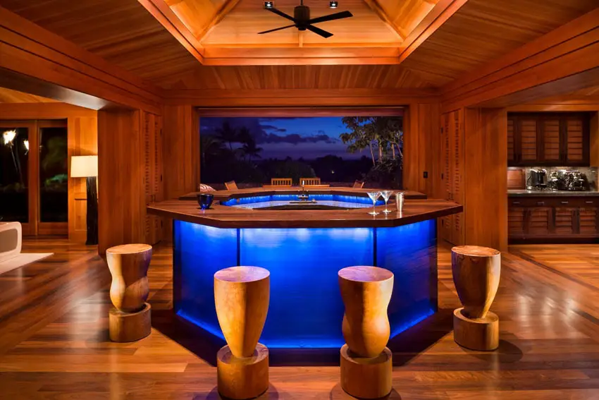 Room with bar with picture window views, solid wooden bar stools and lit blue bar