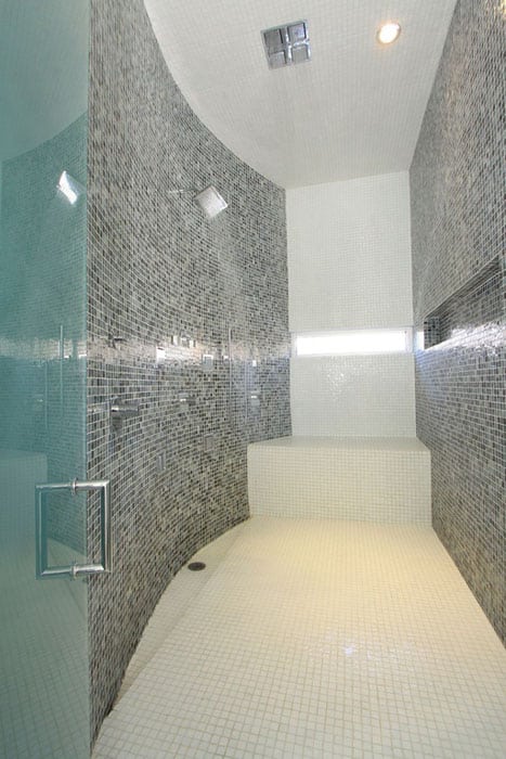 Amazing walk in shower with black and white glass mosaic tile