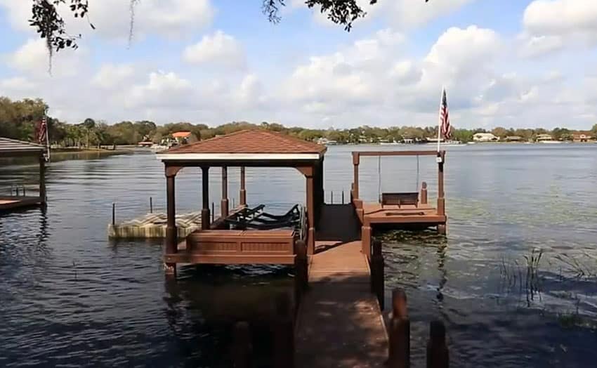 Backyard boat house on lake with wood swing