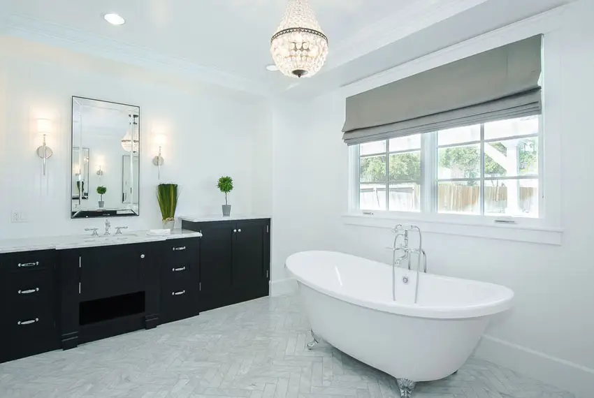 Bathroom with small chandelier and tub with silver feet