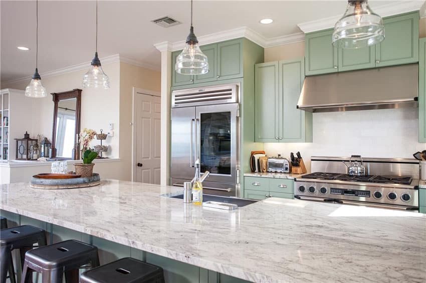 Beach style kitchen with light green cabinets and carrara marble counters