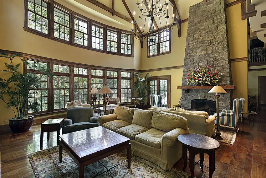 High angled fireplace made of stone, weathered wood window frames and two main seating sets