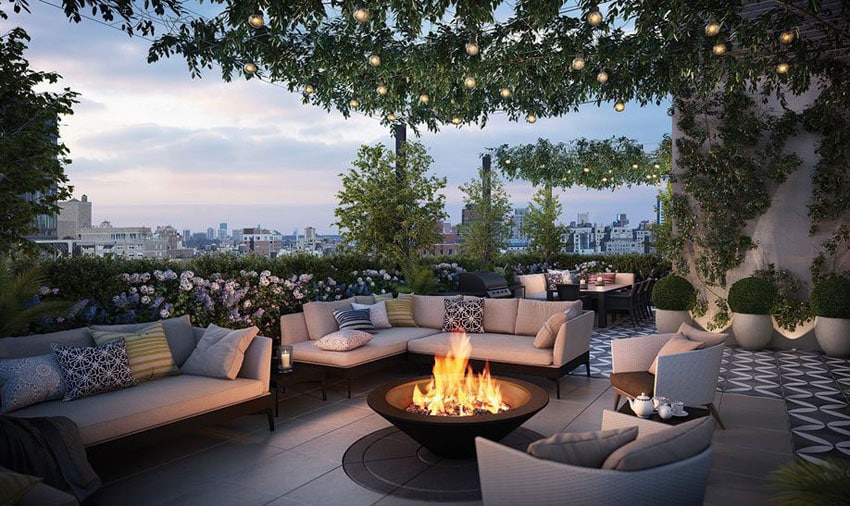 Beautiful rooftop patio area with landscaped plants, outdoor furniture, fire pit and city views