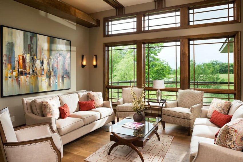 Beautifully decorated craftsman living room with large windows, beam ceiling, wood floors and off white color furniture