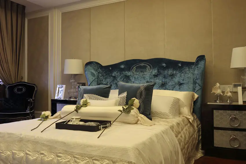 Bedroom with blue fabric headboard, and matching silver front night stands