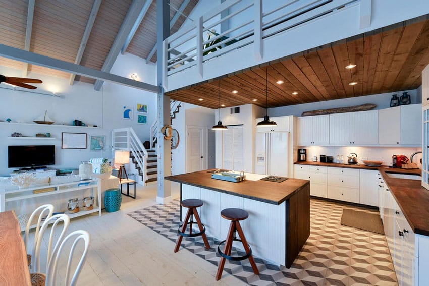 Blue cottage kitchen with wood counter island at beach house with loft