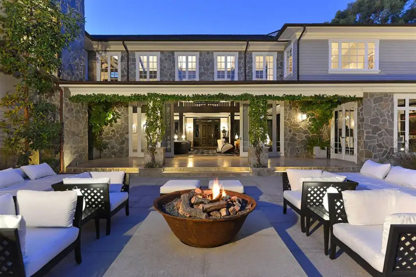 Concrete patio behind luxury estate home with stone construction