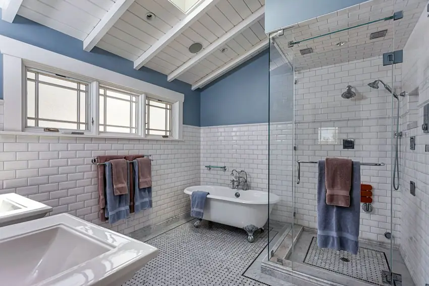 Bathroom with sloped ceiling, window, sink and brown and blue towel 