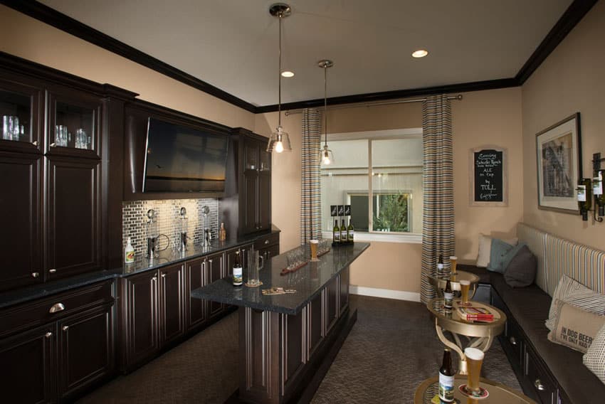 Contemporary home bar with dark wood cabinets and black granite counters