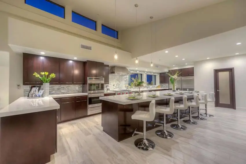 Contemporary kitchen with oak laminate flooring and long breakfast bar island