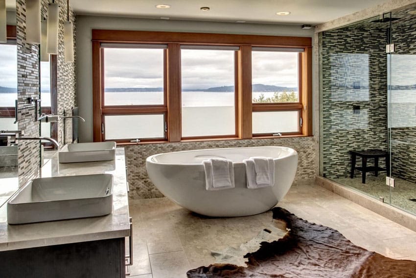 Contemporary lake view bathroom with freestanding tub and glass tile shower