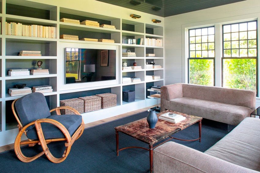 Room with blue rocking chair, storage boxes, television and rug