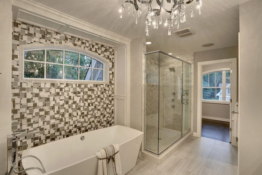 Contemporary master bathroom with acrylic tub mosaic accent wall and porcelain tile floors