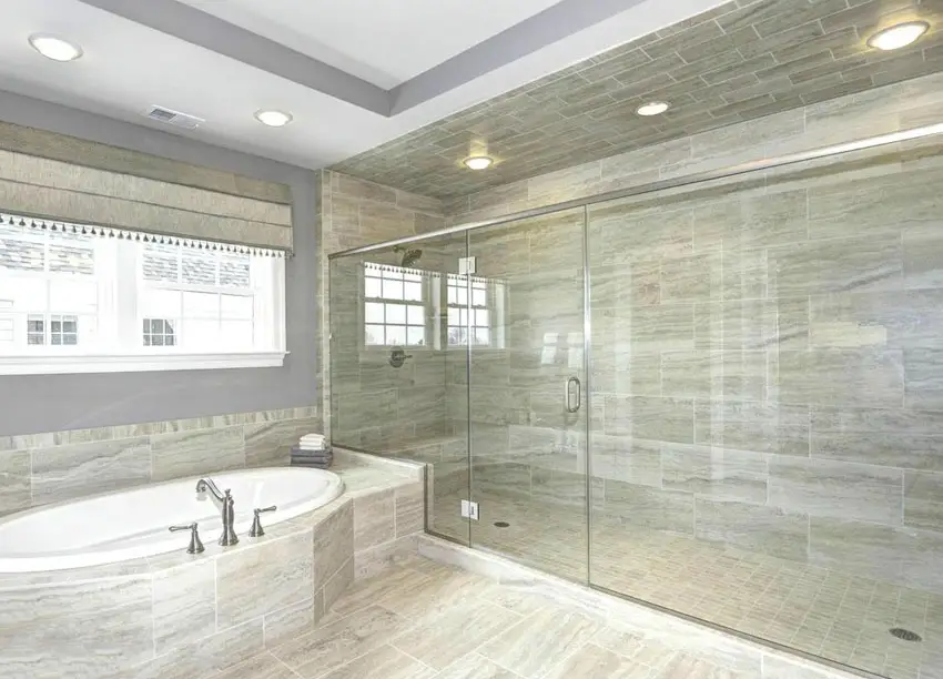 Bathroom with grey shades, granite tub with partition with stainless steel framing