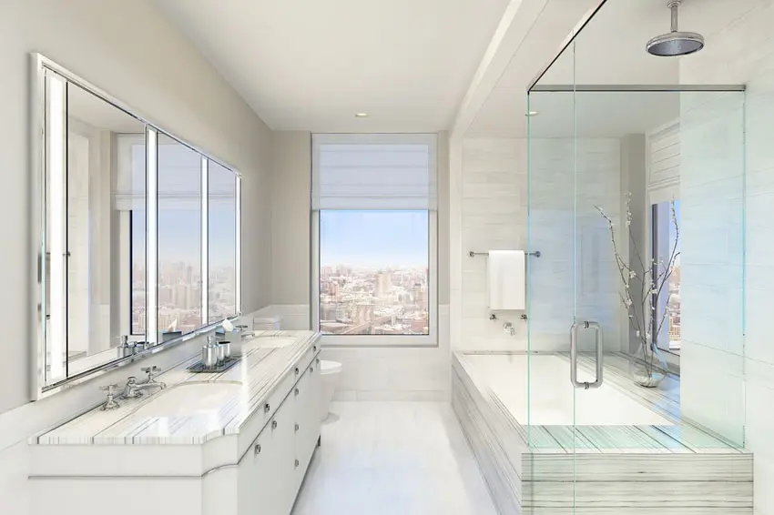 Oatmeal colored walls and shower attached to the ceilingnwith partial view of the city