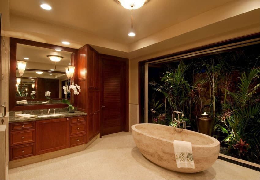 Contemporary master bathroom with sandstone bathtub and tropical plants