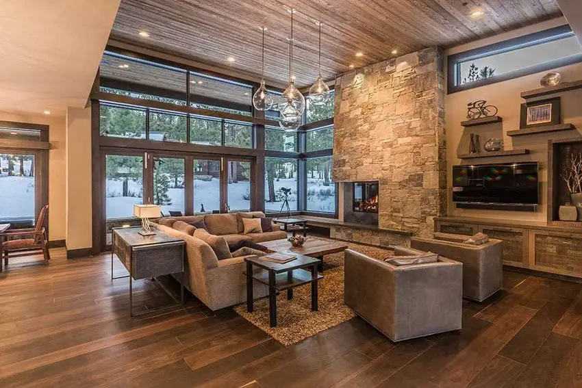 Modern rustic stone and wood living room with fireplace and beautiful views of the outdoors
