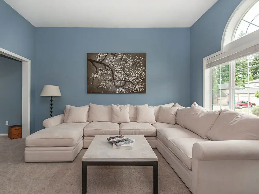 Contemporary living room with blue walls and large white sectional couch