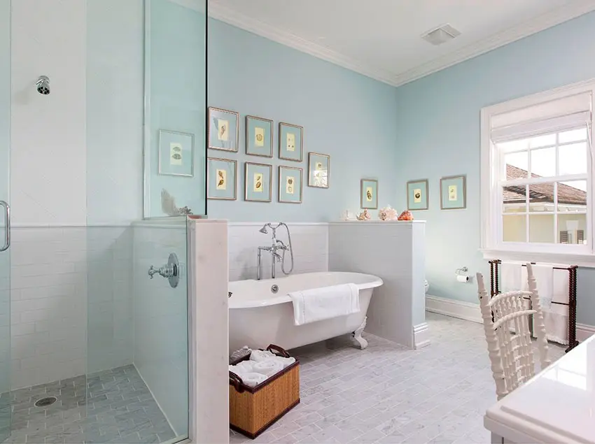 Bathroom with pale blue walls, laundry basket on the floor and towel rack