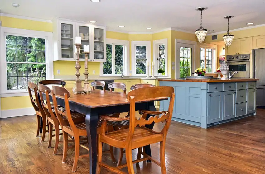 Kitchen with yellow cabinets, blue painted island and mini chandeliers