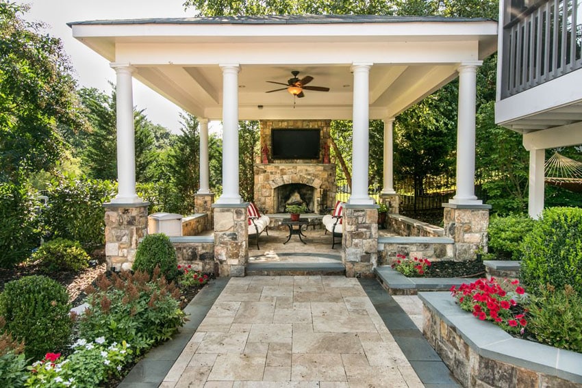 Covered patio with pillars fireplace tv and seating in garden
