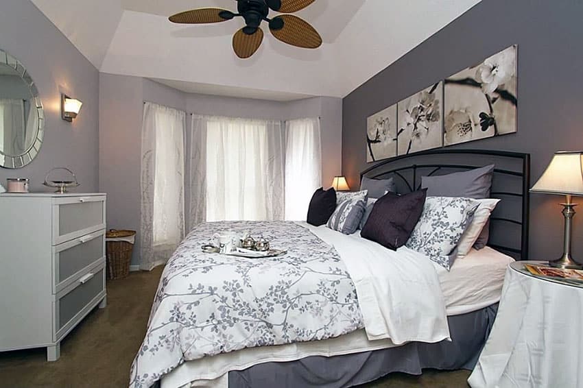 Cozy bedroom with purple and white decor and ceiling fan