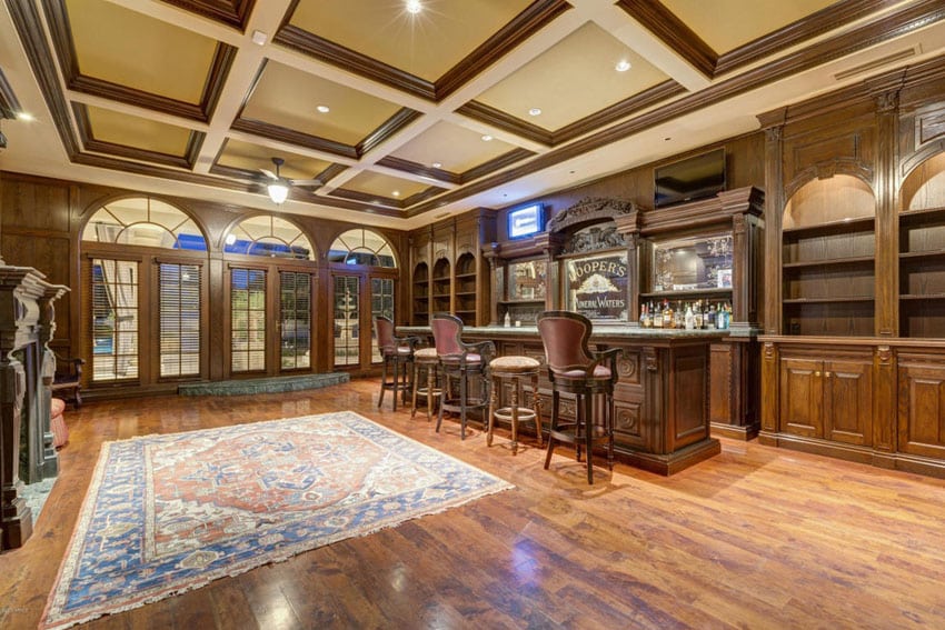 Craftsman custom home bar with decorative cabinetry and high ceilings